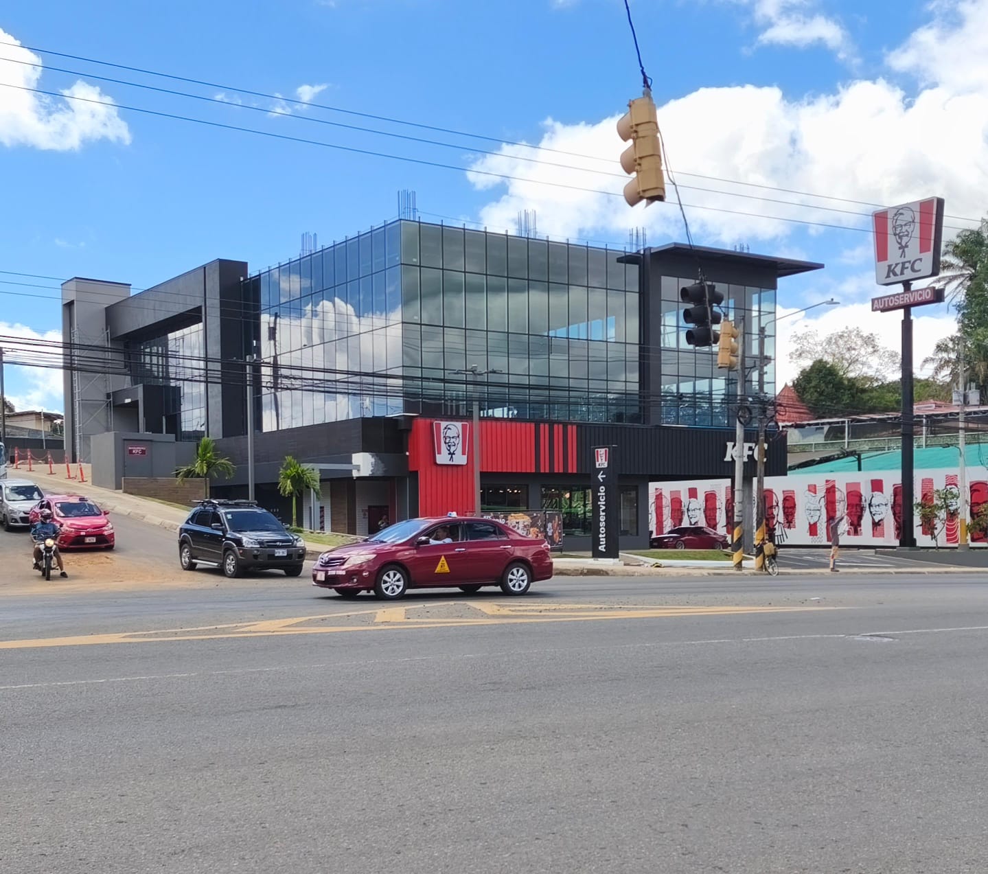 Edificio comercial de 6 pisos terminado con fachada de vidrio negro y local KFC en planta baja, Pérez Zeledón